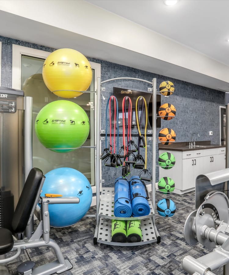 Resident working out with weights at Monark Grove Clarkston in Clarkston, MI
