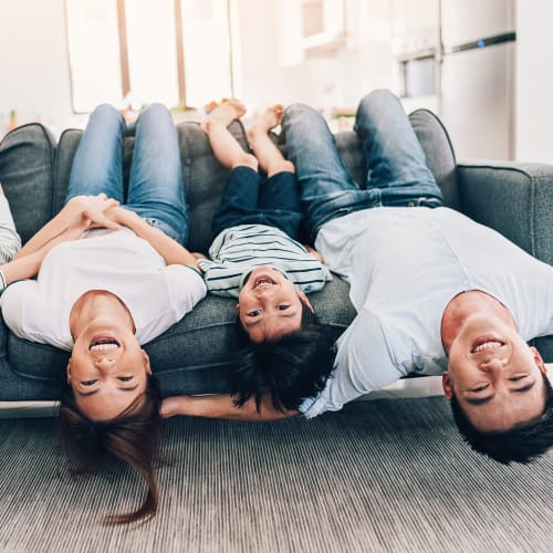 A family sitting upside down on their couch at The Village at Whitehurst Farm in Norfolk, Virginia