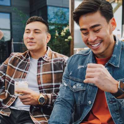 two guys relaxing with cocktails outdoors