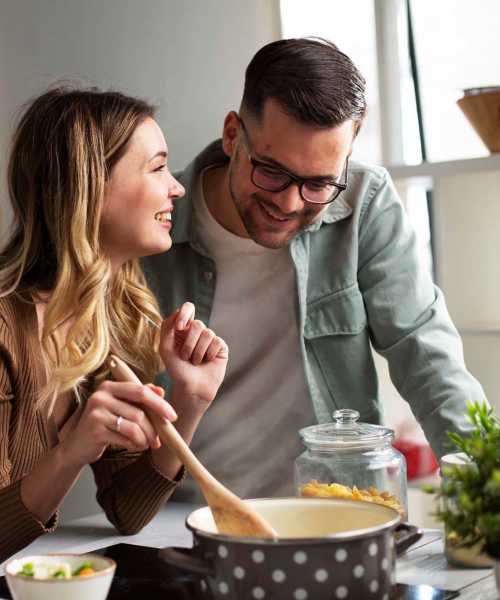 Couple cooking in the kitchen at Pine Cove Apartments in Oregon, Wisconsin