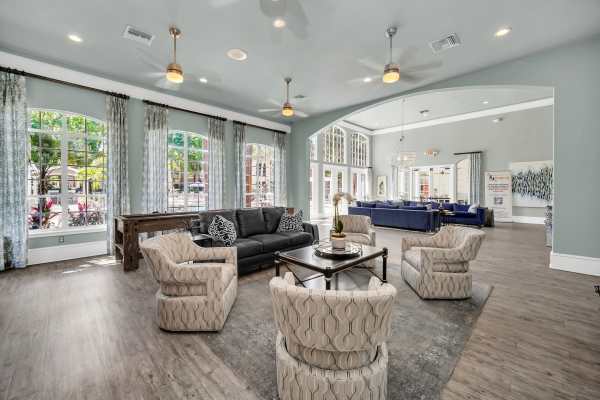 Community clubhouse with lot's of seating and wood-style flooring at The Summit At Metrowest in Orlando, Florida