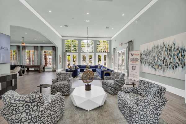 Community clubhouse with lot's of seating, flat television screen and wood-style flooring at The Summit At Metrowest in Orlando, Florida
