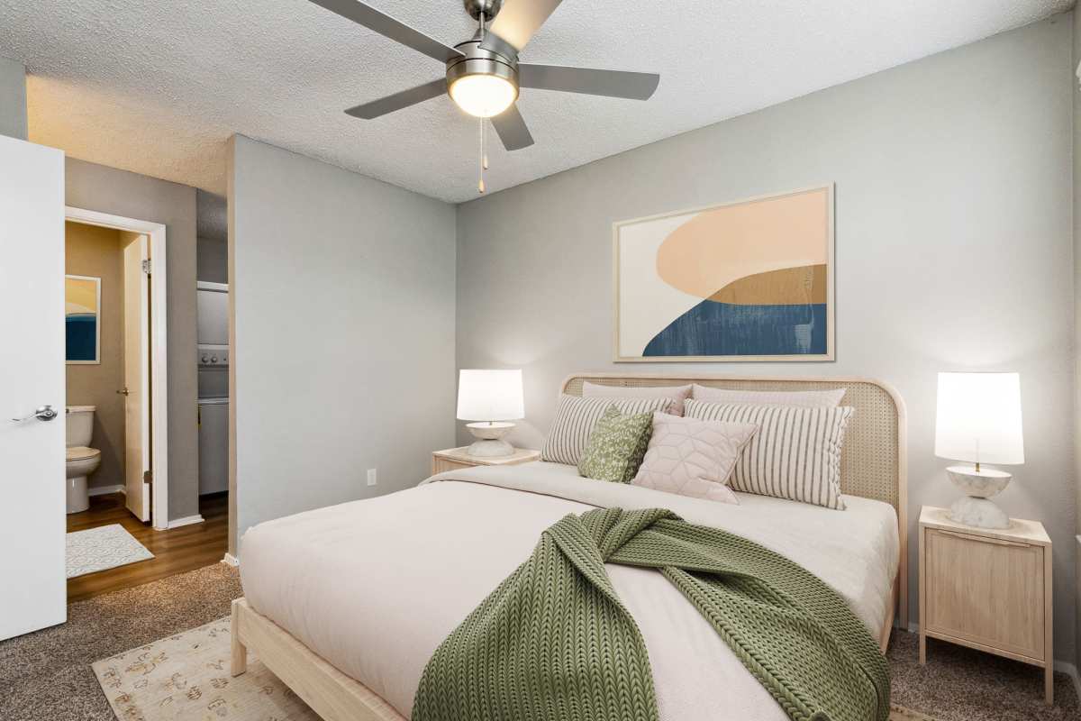 Model bedroom with carpeting and en-suite bathroom at Hunters Glen in Killeen, Texas
