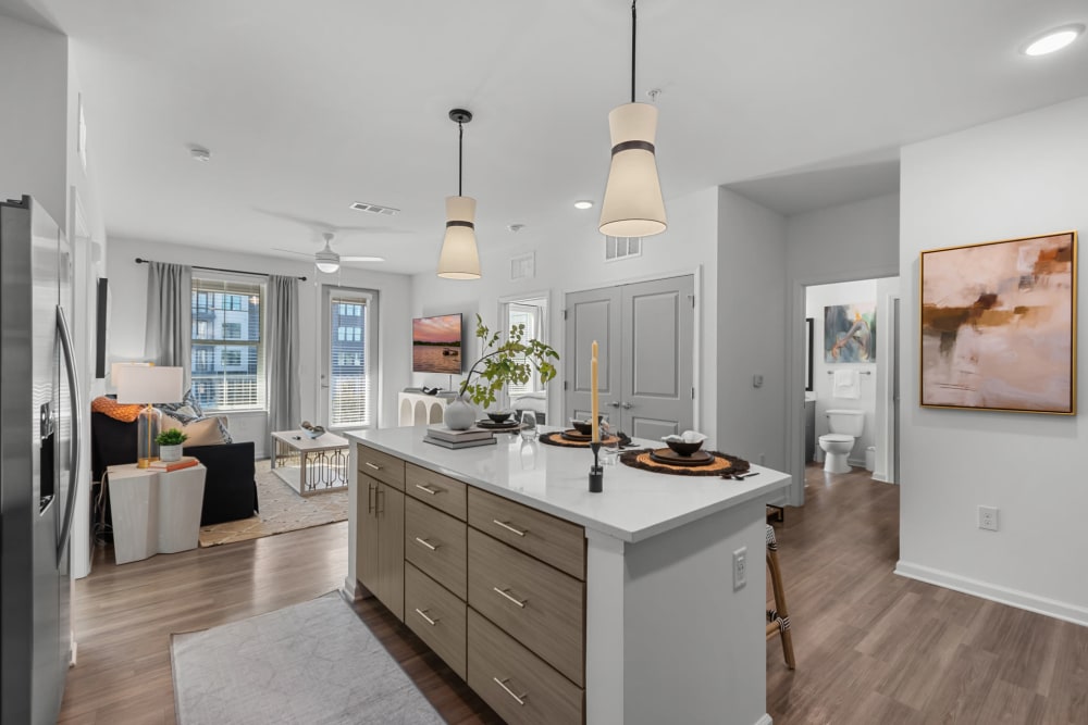 Kitchen with island seating and a spacious living room at Palmilla | Apartments & Townhomes in Pensacola, Florida