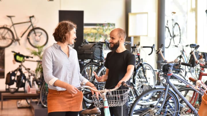 A man and a woman converse in a bike store | Albuquerque bike shops