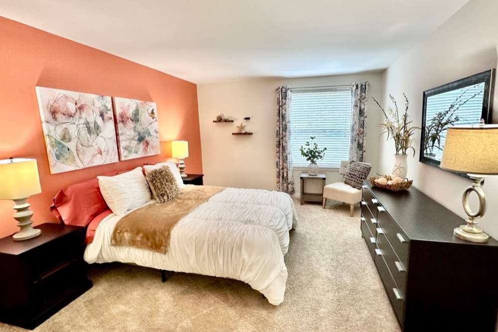 a bedroom with orange walls at Aspen Apartments in Virginia Beach, Virginia