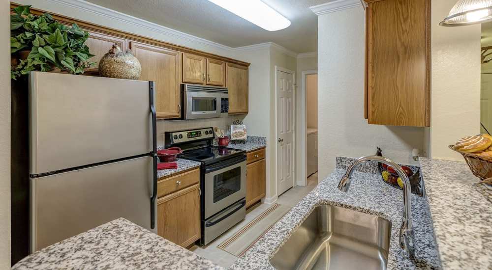 Fully-equipped kitchen with granite countertop and stainless-steel appliances at Verandas at Mitylene in Montgomery, Alabama