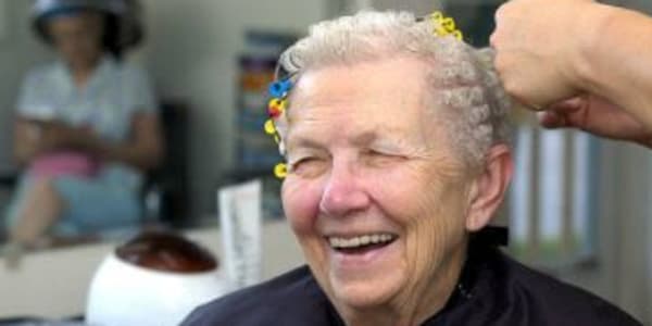 Resident sitting and getting her hair done at Maple Ridge Care Center in Spooner, Wisconsin