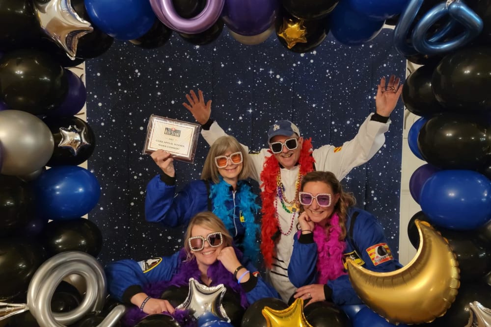 Employees playing dress up with balloons and scarves at Ray Stone Inc.