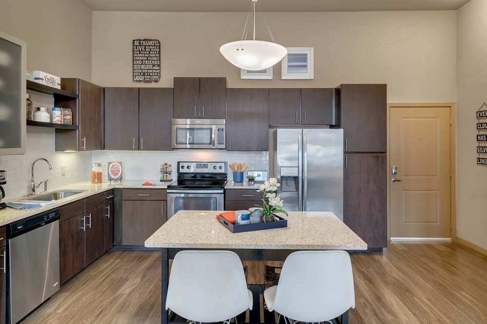 Apartment kitchen with dark wood cabinets and major appliances at Station House at Lake Mary in Lake Mary, Florida