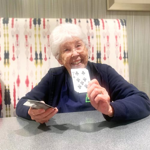 A resident laughing while doing arts & crafts at Oxford Villa Active Senior Apartments in Wichita, Kansas
