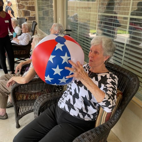 Patio seating by the garden at Saddlebrook Oxford Memory Care in Frisco, Texas