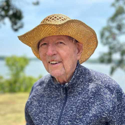 Smiling resident by a tree at Oxford Glen Memory Care at Owasso in Owasso, Oklahoma