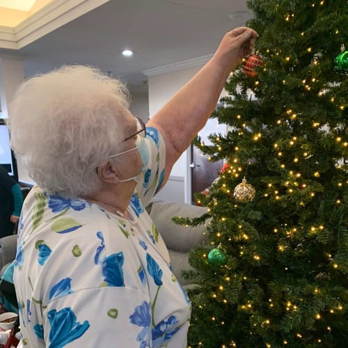 A resident decorating the tree at Madison House in Norfolk, Nebraska