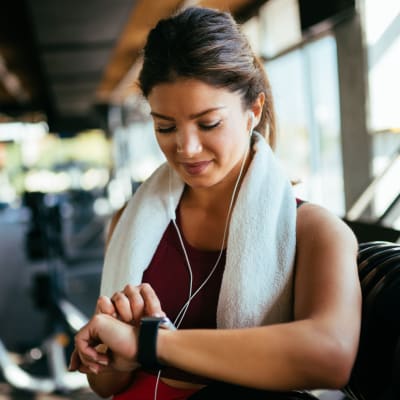 Woman in workout gear checking watch at Constellation Park in Lemoore, California