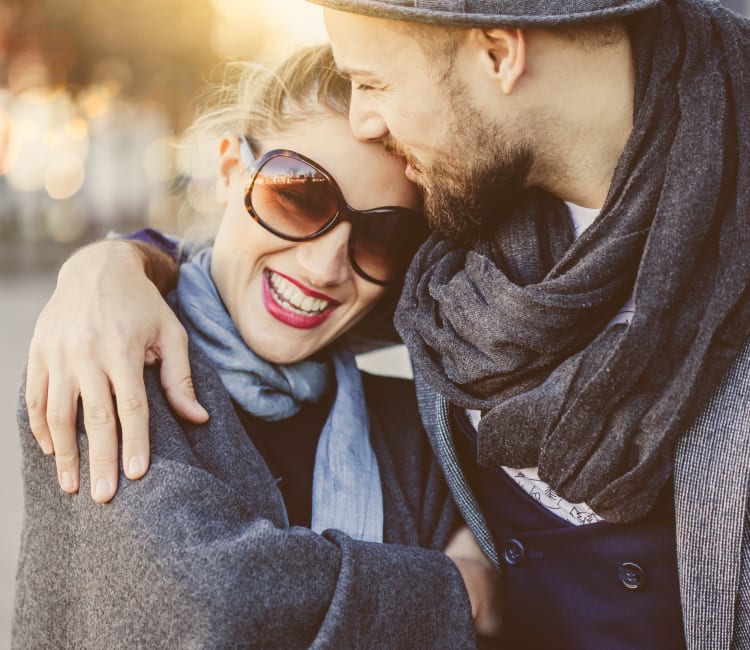 Resident couple enjoying a laugh together as they walk around the neighborhood at Sofi at 50 Forest in Stamford, Connecticut