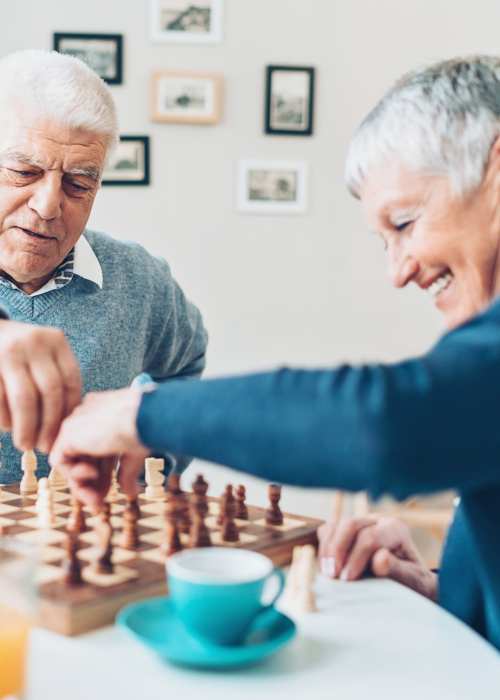 Two residents playing chess at The Pineapple House at Sapphire Lakes in Naples, Florida