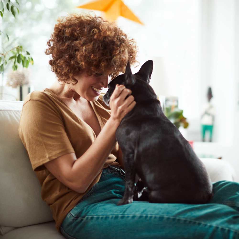 Resident and her puppy relaxing on the couch in their new apartment at Village Lake Townhomes in Smyrna, Tennessee