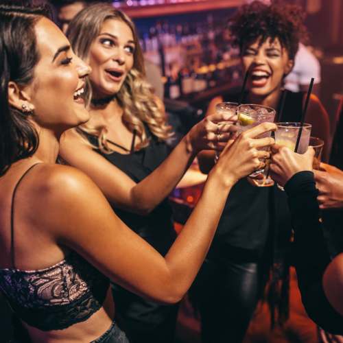 A group of friends toasting their glasses near Monaco South in Denver, Colorado