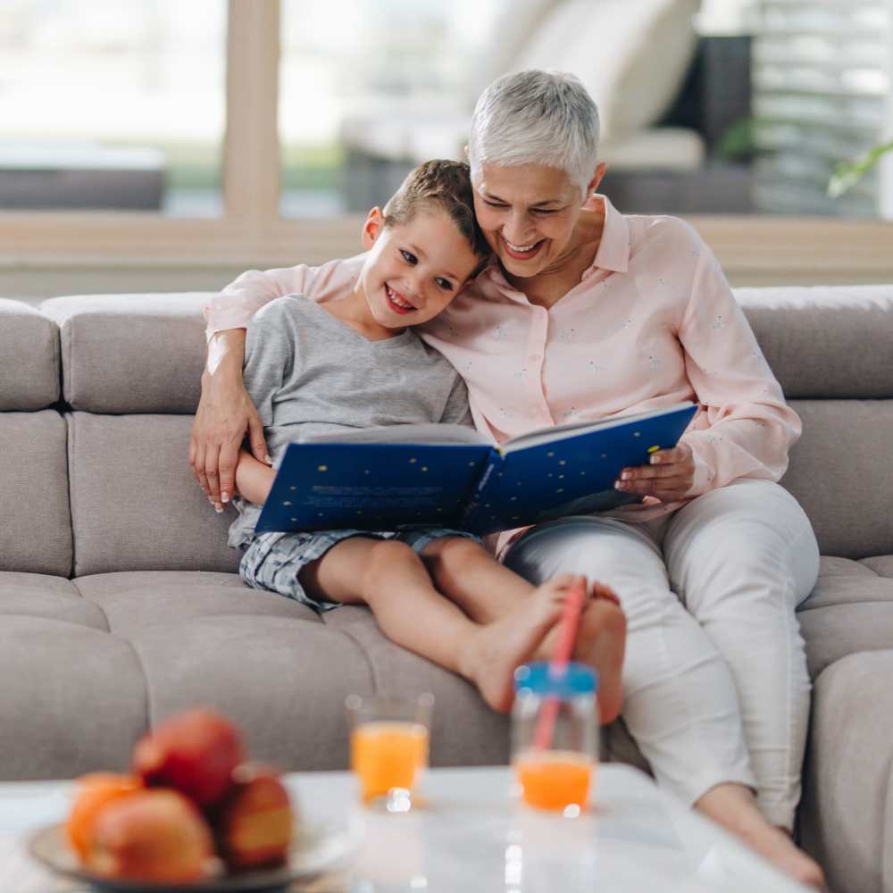 Resident with kid helping him to study on couch of an apartment home at The Residences at Patapsco in Ellicott City, Maryland
