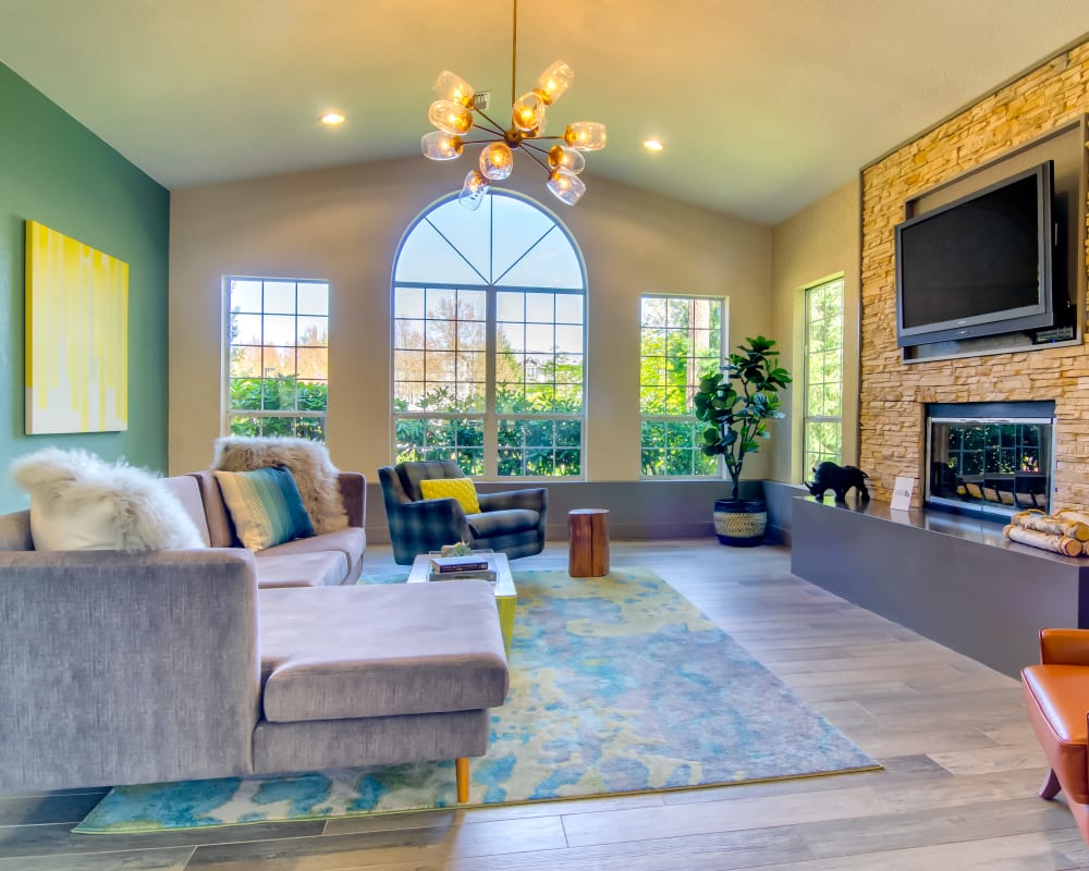 Resident clubhouse lounge with a fireplace and flatscreen TV at Sofi at Murrayhill in Beaverton, Oregon