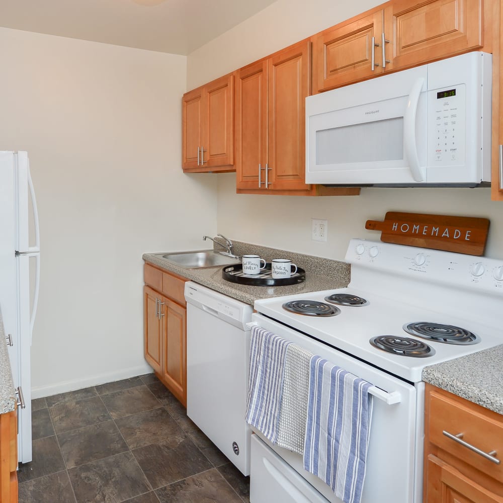 Kitchen with maple cabinets and white appliances Warwick Terrace Apartment Homes in Somerdale, New Jersey