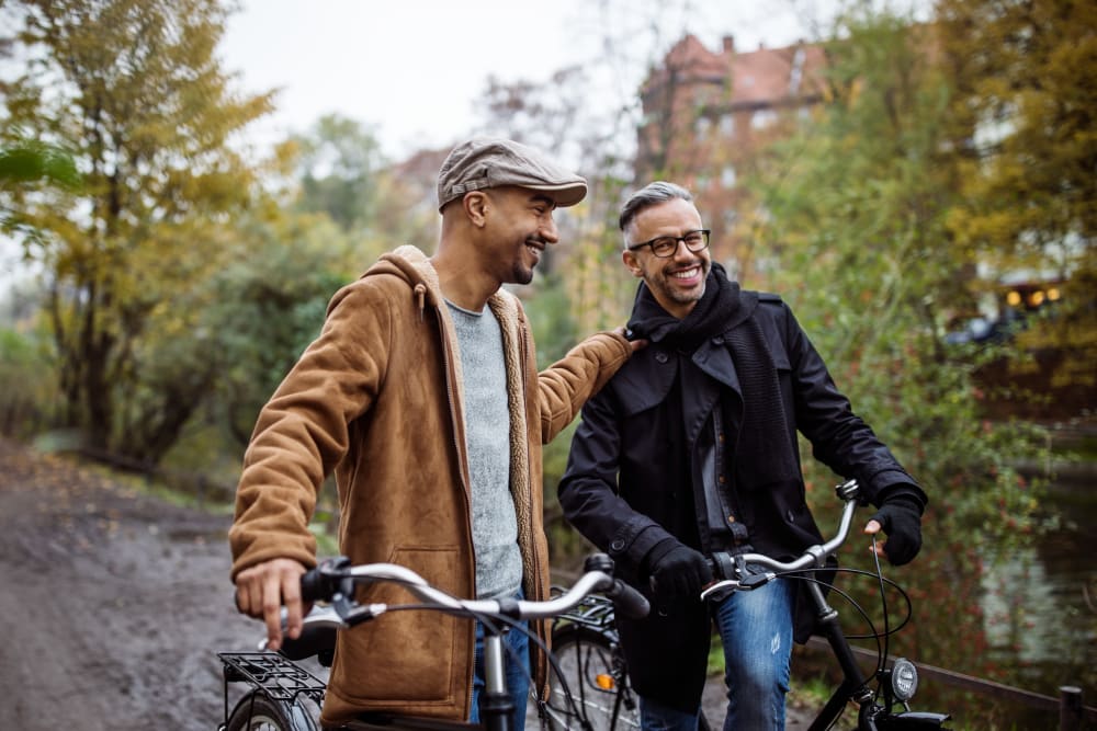 Residents walking their bikes along a riverside path near The Meridian in Salem, Oregon