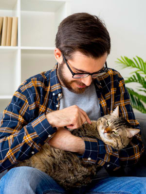 Resident petting his cat in his home at Latigo at Eagle Pass in Eagle Pass, Texas