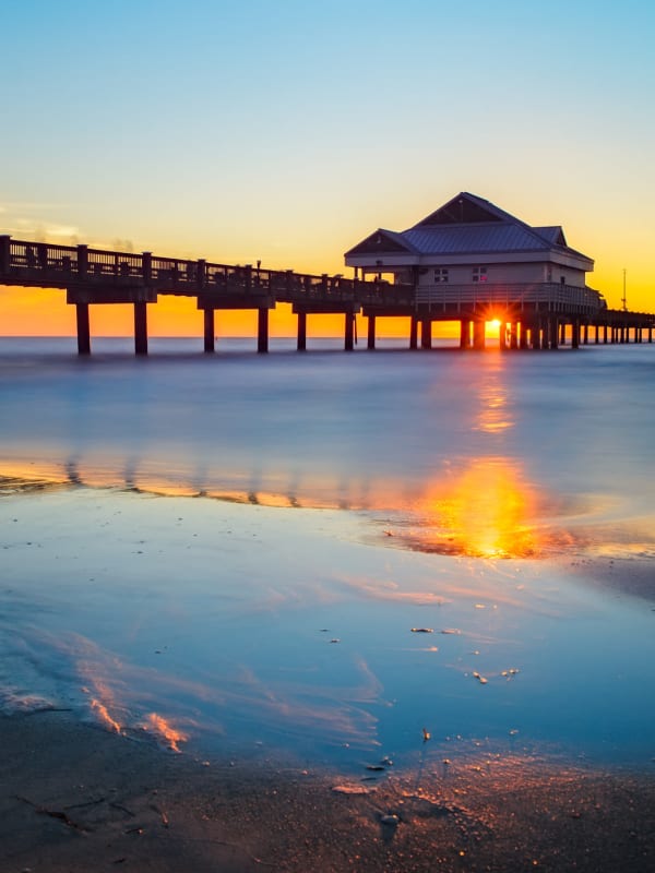 Sun setting behind a pier near Savannah Place Apartments & Townhomes in Boca Raton, Florida