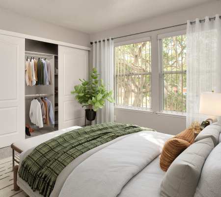 Bedroom with closet and large window at Seventeen Mile Drive Village Apartment Homes in Pacific Grove, California