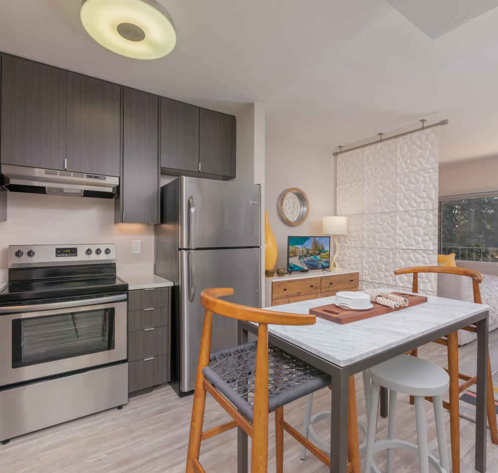 Chef-inspired kitchen with dark wood cabinetry and hardwood flooring in a model home at Mia in Palo Alto, California