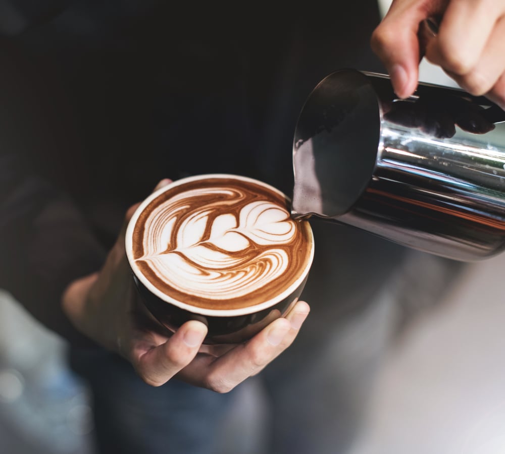 Barista pouring an artful latte at a café near Terra Camarillo in Camarillo, California