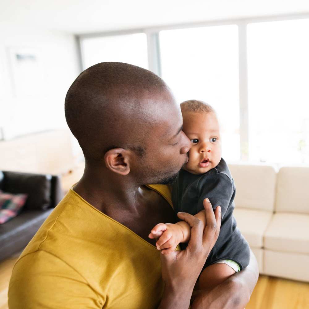 Resident and his baby in their living room at Franklin Pointe in Reed City, Michigan