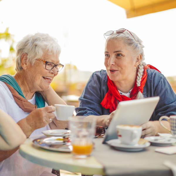 Two residents looking at a computer at Pacifica Senior Living Encinitas in Encinitas, California