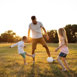 Father and kids playing soccer on the lawn at Buffalo Ranch in Farmersville, Texas