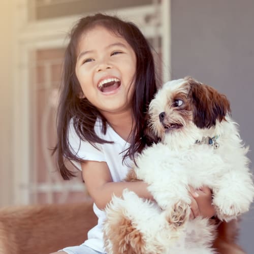 A child holding a small dog at Silver Strand II in Coronado, California