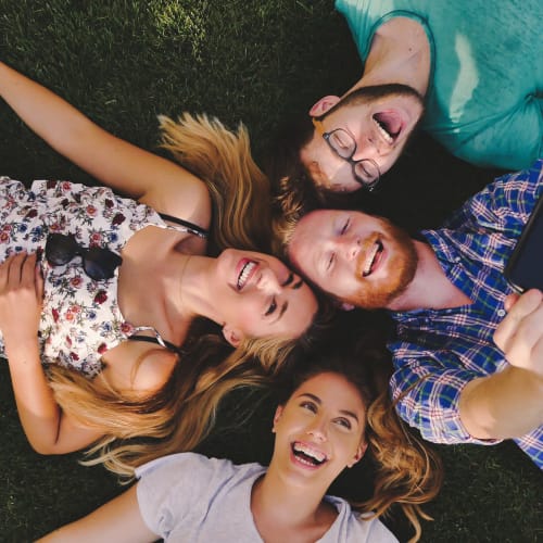 Happy residents laying down in the grass at Ben Moreell in Norfolk, Virginia