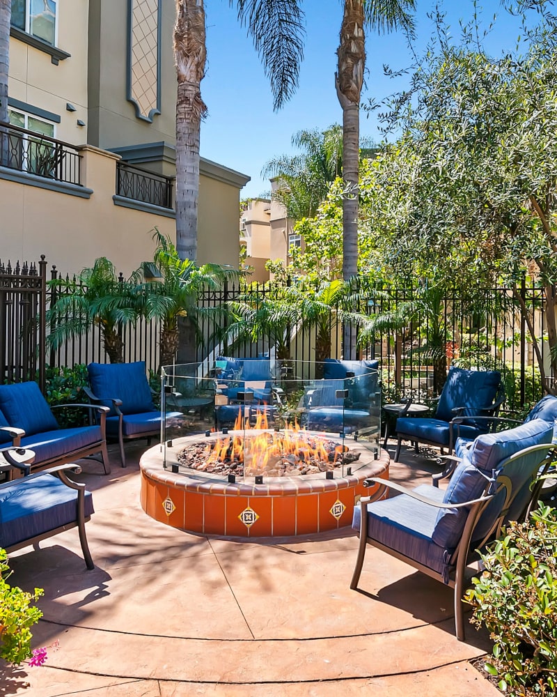 Outdoor fire pit surrounded by blue chairs at Playa Del Oro, Los Angeles, California