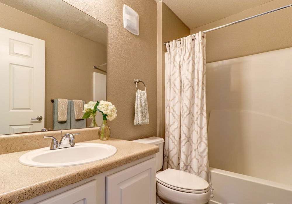 Spacious bathroom with vanity light, mirror, sink and bathtub at The Reserve at Kanapaha in Gainesville, Florida