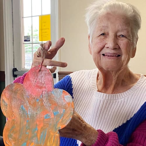 Smiling resident holding an art project at Canoe Brook Assisted Living in Duncan, Oklahoma