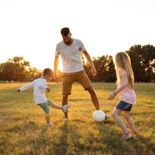 A resident playing soccer with children at Midway Manor in Virginia Beach, Virginia