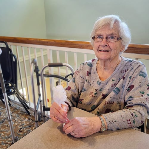 A resident holding a pink dreamcatcher at Canoe Brook Assisted Living & Memory Care in Catoosa, Oklahoma