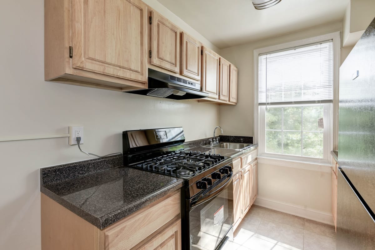 Nice black countertops and light wood cabinets in the kitchen at Chillum Manor in Washington, District of Columbia