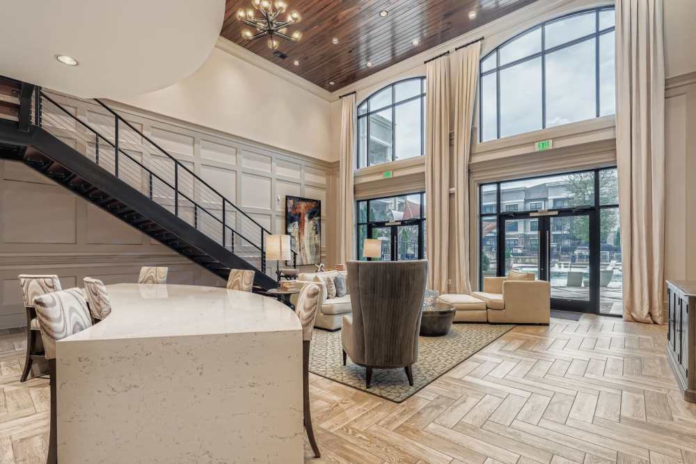 A sophisticated living space featuring elegant armchairs, a stylish coffee table, and a cozy fireplace, adorned with soft lighting and refined decor for a welcoming ambiance. 2370 Main at Sugarloaf in Duluth, Georgia