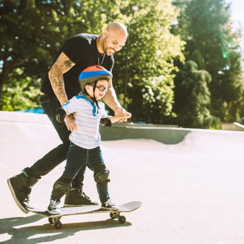 A resident helping his child skateboard at Orleck Heights in San Diego, California