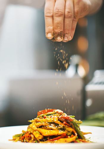 Chef seasoning a dish with spices at a restaurant near Copper River in Spokane, Washington