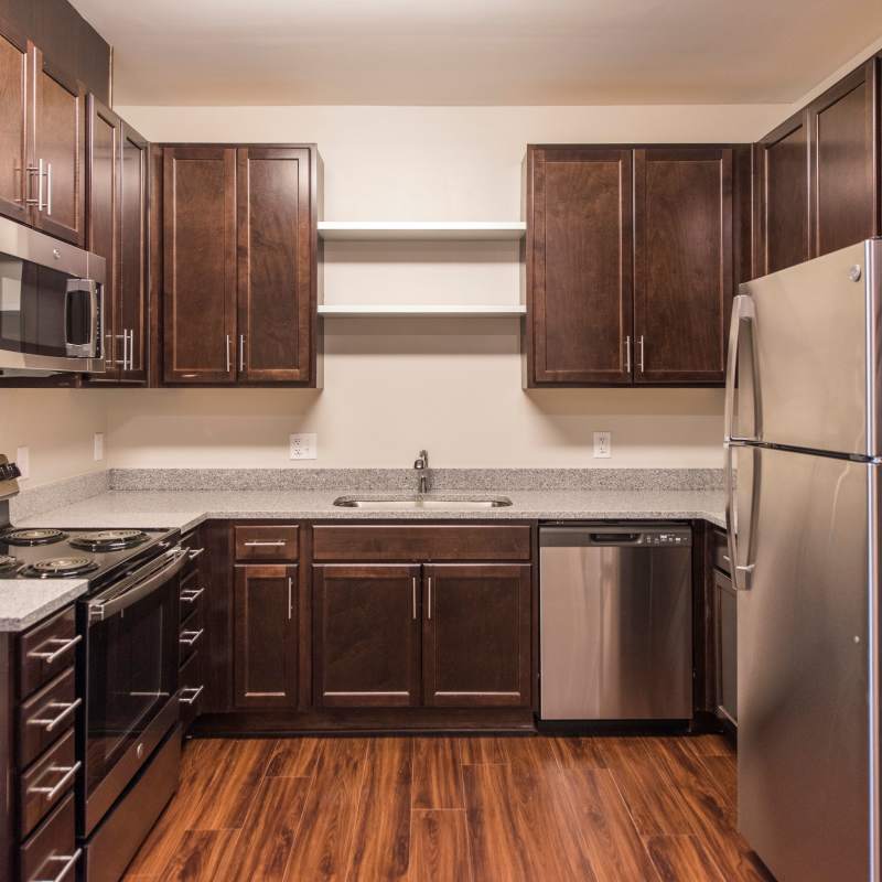 Kitchen with stainless-steel appliances and wood-style floor at Palmer's Creek, Fredericksburg, Virginia