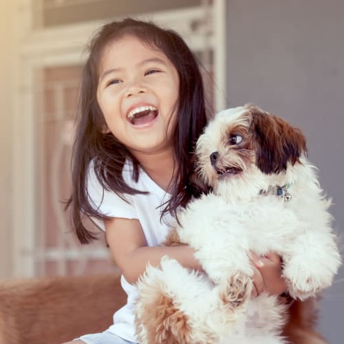 A child holding a small dog at Lovell Cove in Patuxent River, Maryland