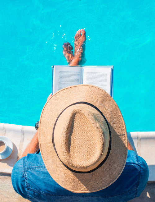 Resident reading by the pool at Vista Apartments in Chula Vista, California