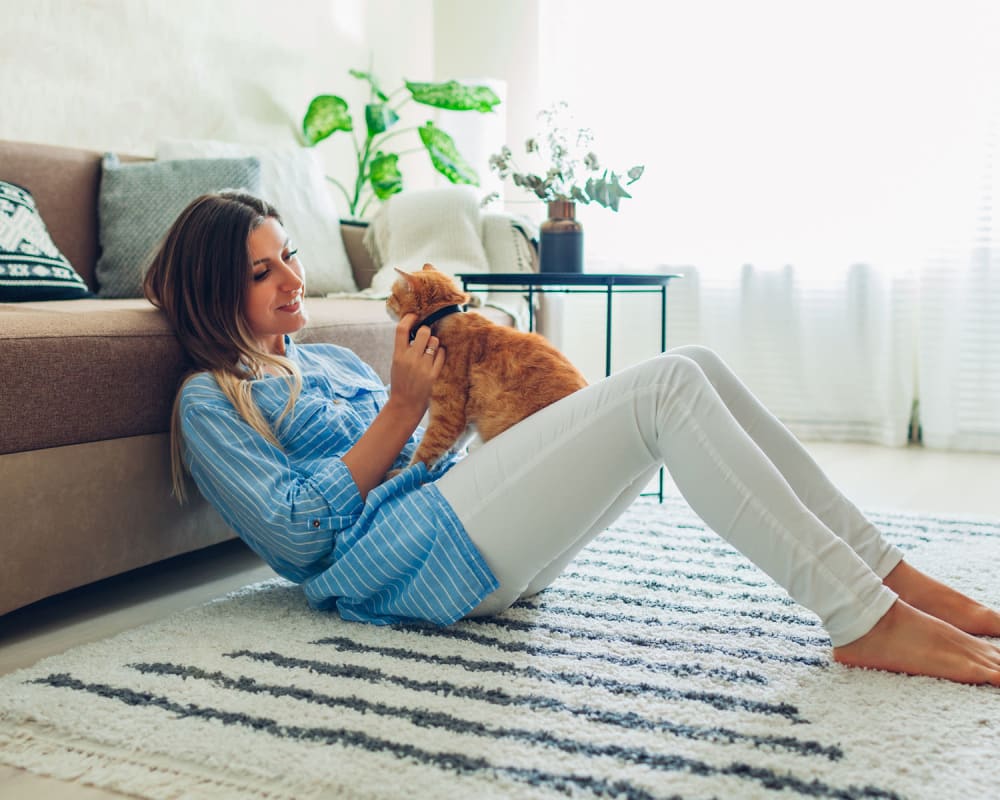 Cat and her owner relaxing together in the living area of their apartment at Oaks Braemar in Edina, Minnesota